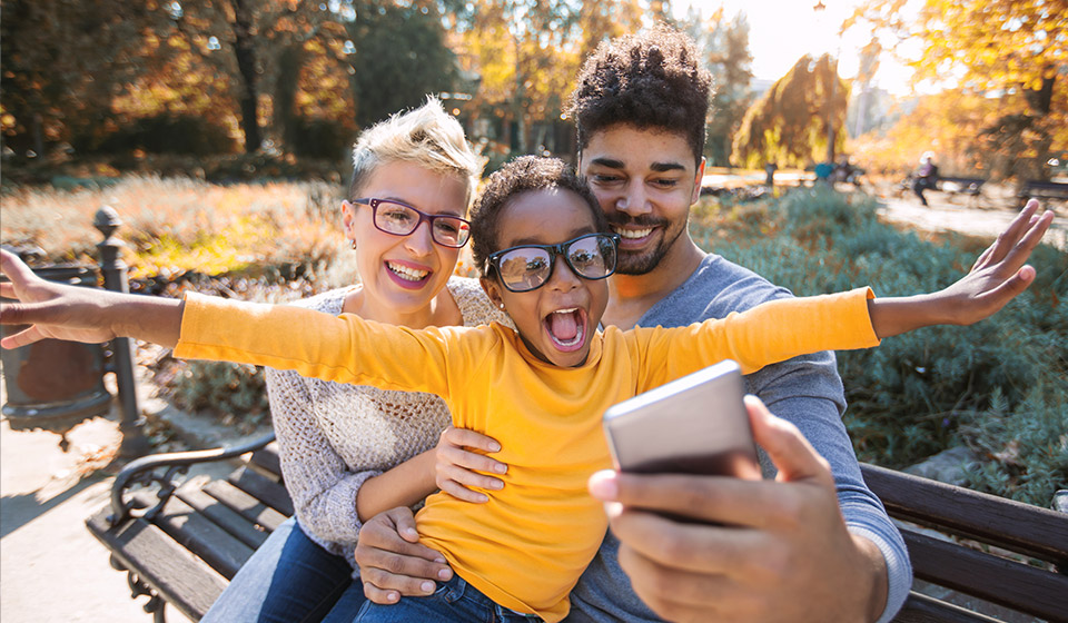Husband and wife with their child smiling and laughing.