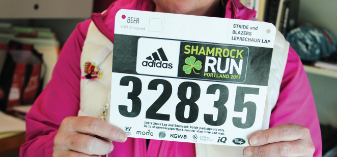 Trin Cramer-Eves holds up the Shamrock Run bib number issued to Shell Martin. Cramer-Eves will wear it at the Shamrock Run in Martin's honor