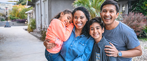 A family all happy and hugging each other outside.
