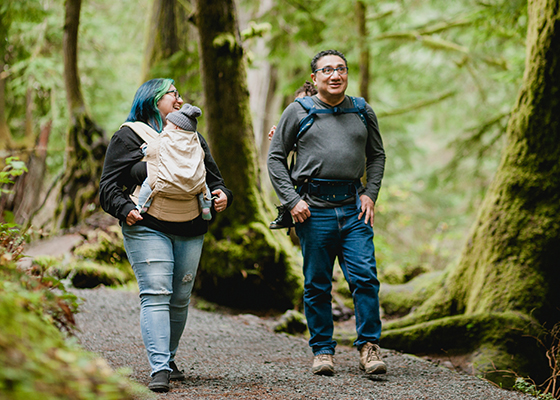 Couple with baby walking through the woods