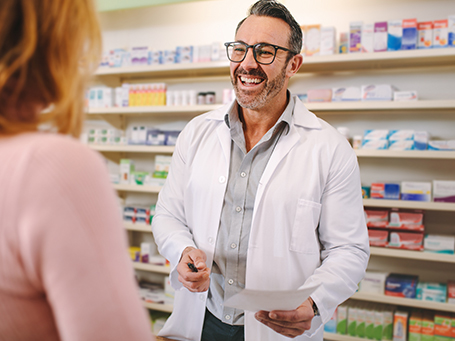 Pharmacist talking to woman in store