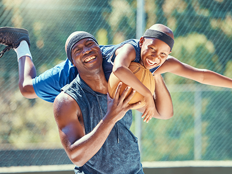 Happy man and boy playing basketball