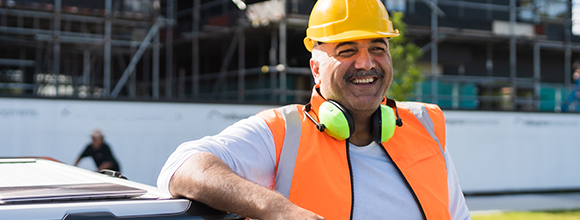 Happy man in hard hat and safety vest