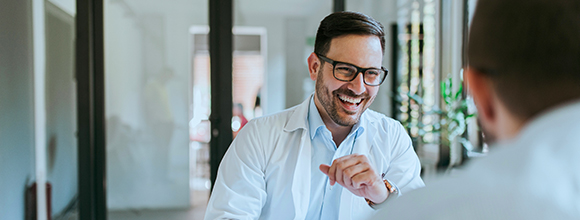 Man in lab coat chuckling