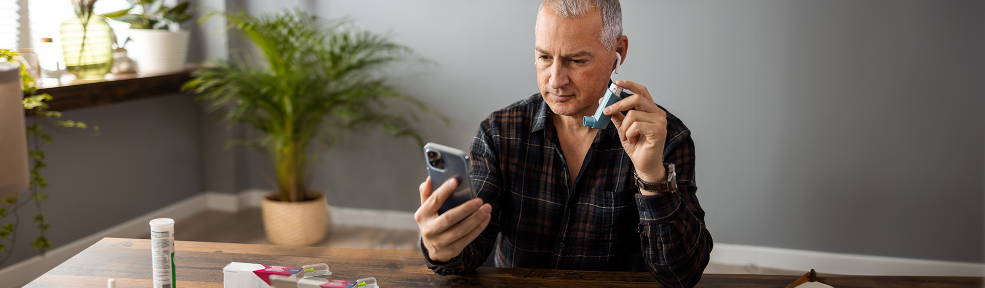 A man on the phone with an inhaler for chronic illness